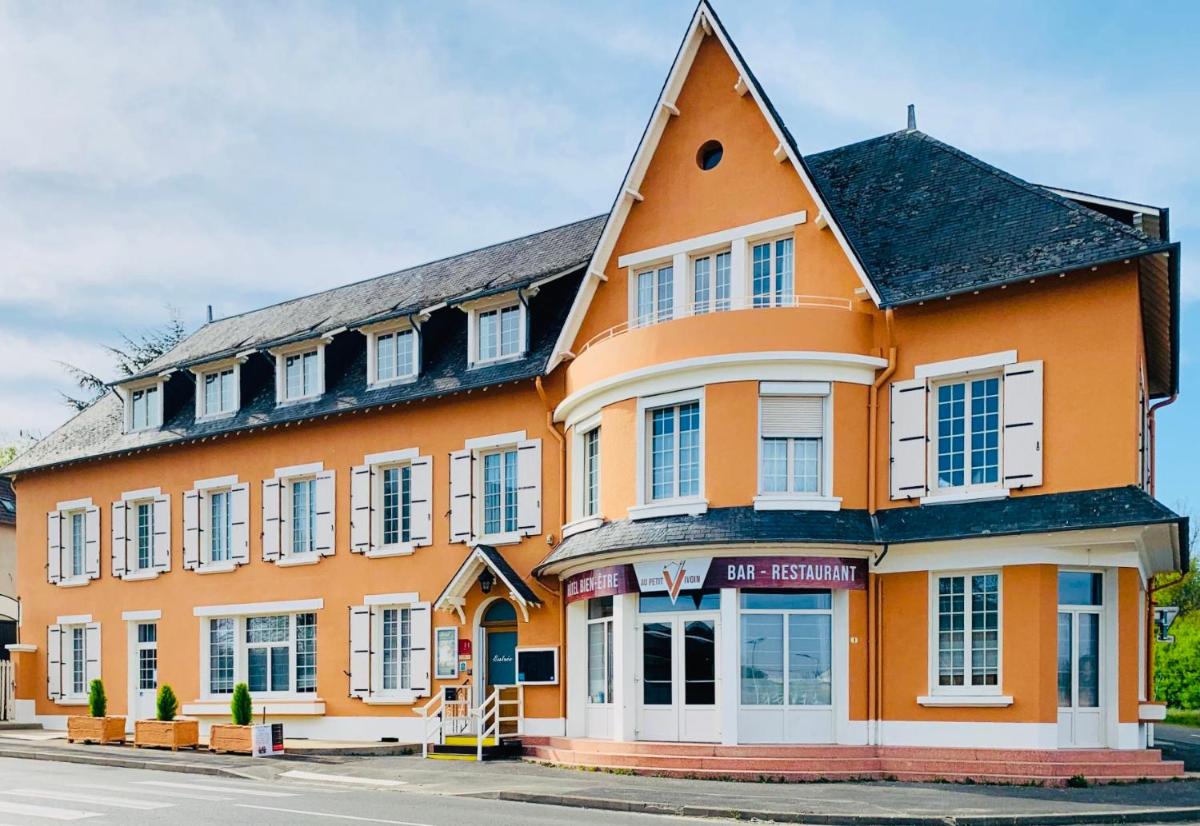 un bâtiment orange avec des fenêtres blanches sur une rue dans l'établissement Au Petit Vivoin, à Vivoin