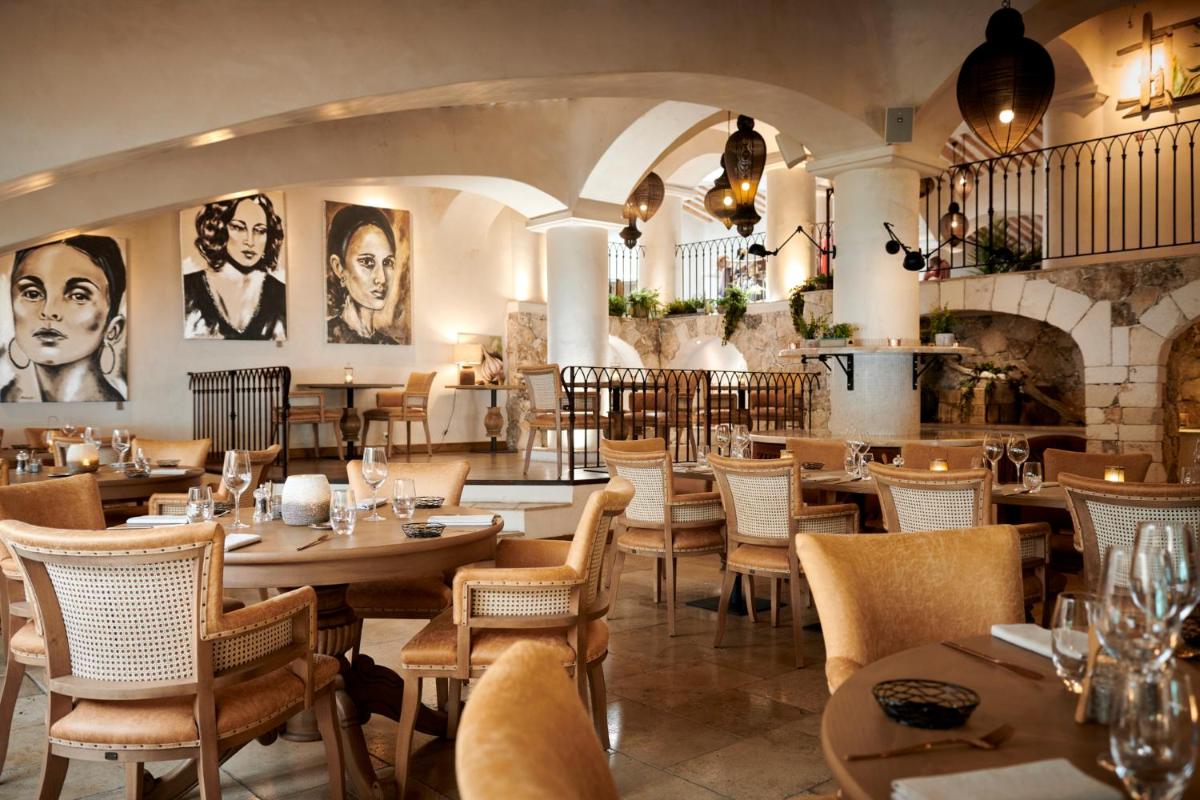 un restaurant avec des tables et des chaises et une cheminée dans l'établissement U Capu Biancu, à Bonifacio