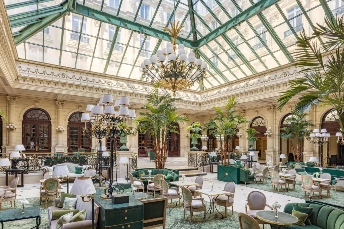 un hall d'entrée avec des tables et des chaises et un plafond de verre dans l'établissement InterContinental Paris Le Grand by IHG, à Paris