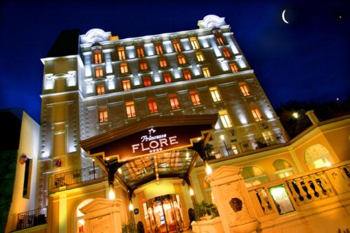 un grand bâtiment avec une enseigne sur la façade dans l'établissement Hôtel Princesse Flore, à Royat