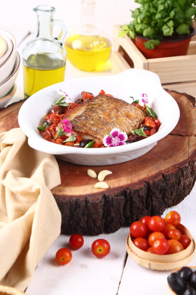 a plate of food sitting on a table with tomatoes at Park Hyatt Hotel and Residences, Hyderabad in Hyderabad