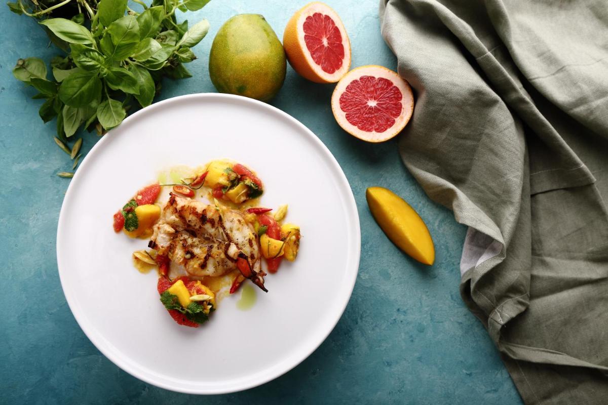 a white plate of food on a table with fruit at Park Hyatt Hotel and Residences, Hyderabad in Hyderabad