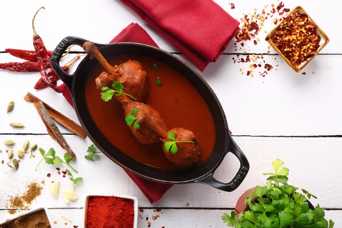 a pan filled with chicken legs in a sauce at Park Hyatt Hotel and Residences, Hyderabad in Hyderabad