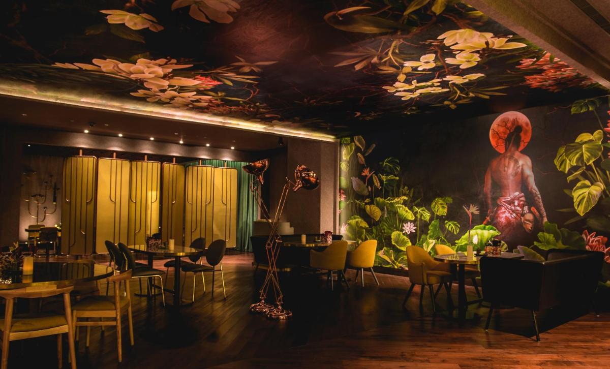 a restaurant with tables and chairs and a painting on the ceiling at Park Hyatt Hotel and Residences, Hyderabad in Hyderabad