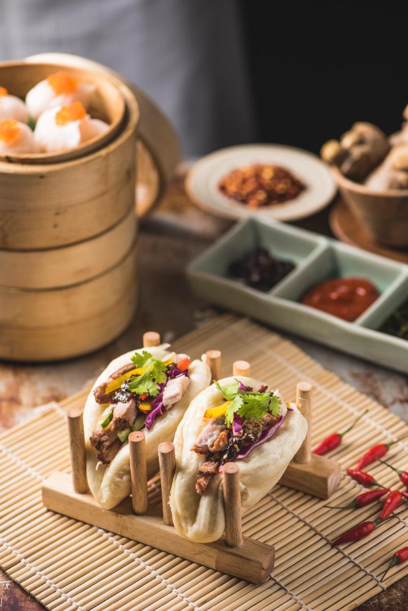 two tacos on a wooden tray with other food at Park Hyatt Hotel and Residences, Hyderabad in Hyderabad