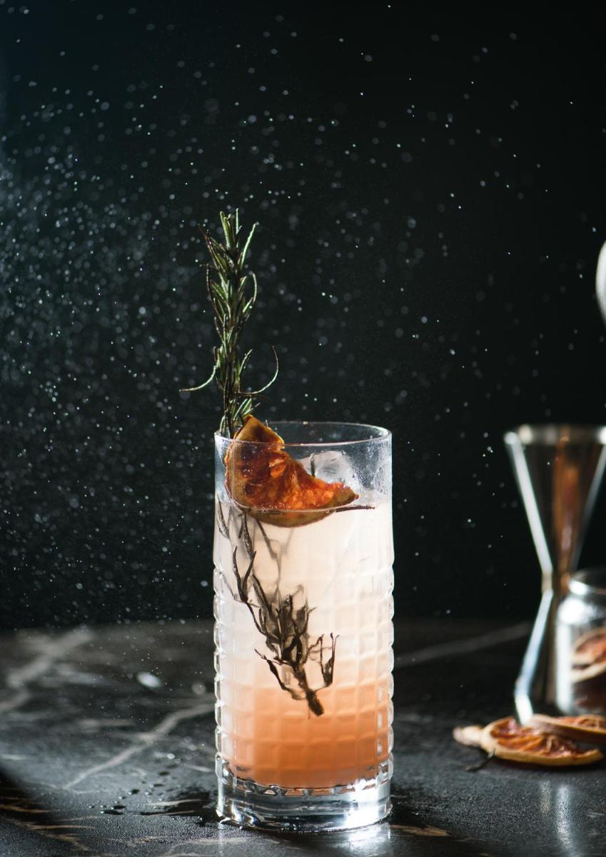 a glass with a drink with a garnish on a table at Park Hyatt Hotel and Residences, Hyderabad in Hyderabad