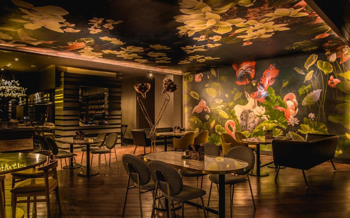 a restaurant with tables and chairs and a floral mural at Park Hyatt Hotel and Residences, Hyderabad in Hyderabad