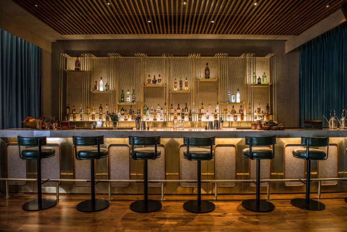 a bar at a hotel with stools in front of it at Park Hyatt Hotel and Residences, Hyderabad in Hyderabad