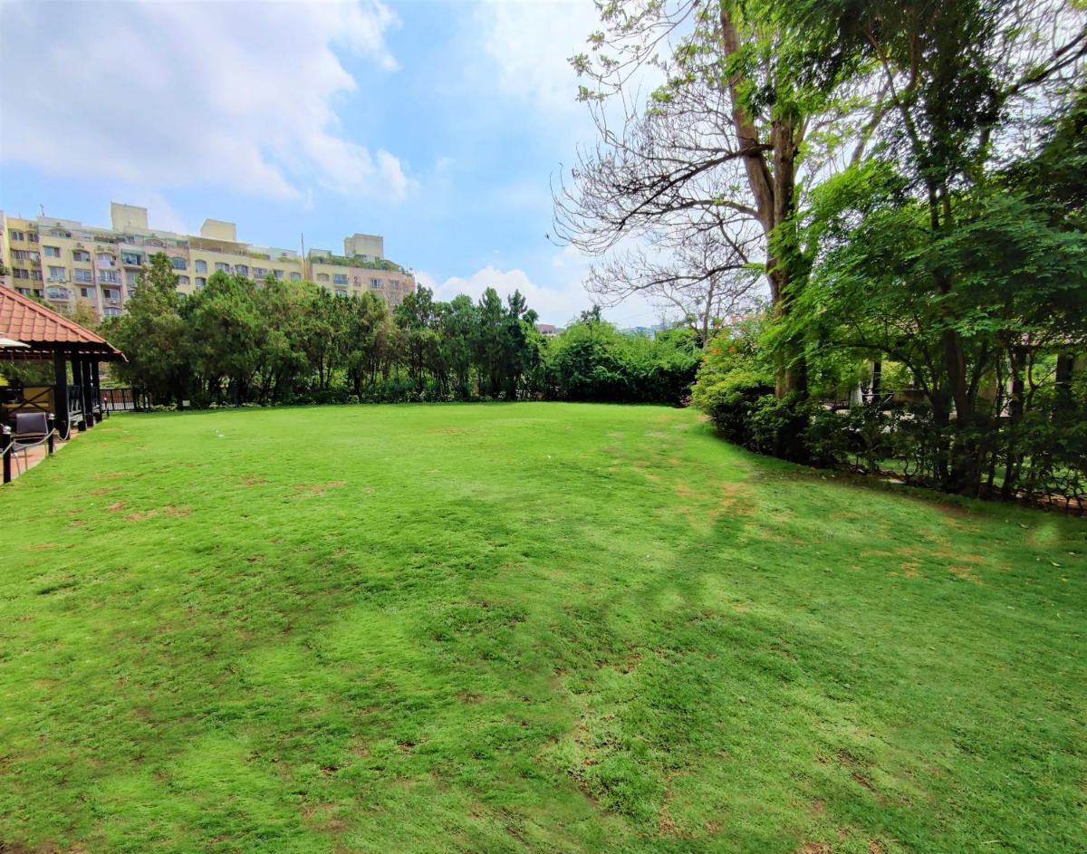 a large field of grass with a building in the background at Hotel Royal Orchid Bangalore in Bengaluru