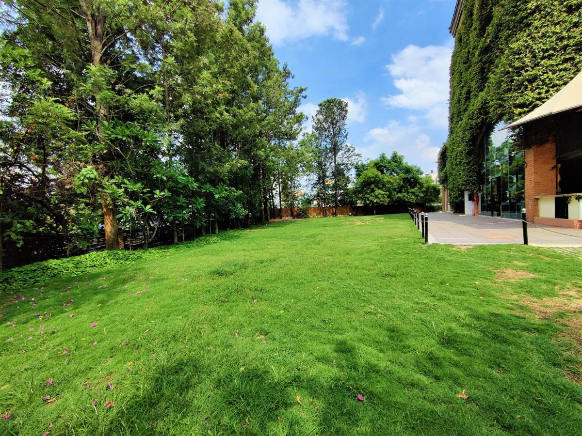 a large grass field with a bench in a park at Hotel Royal Orchid Bangalore in Bengaluru