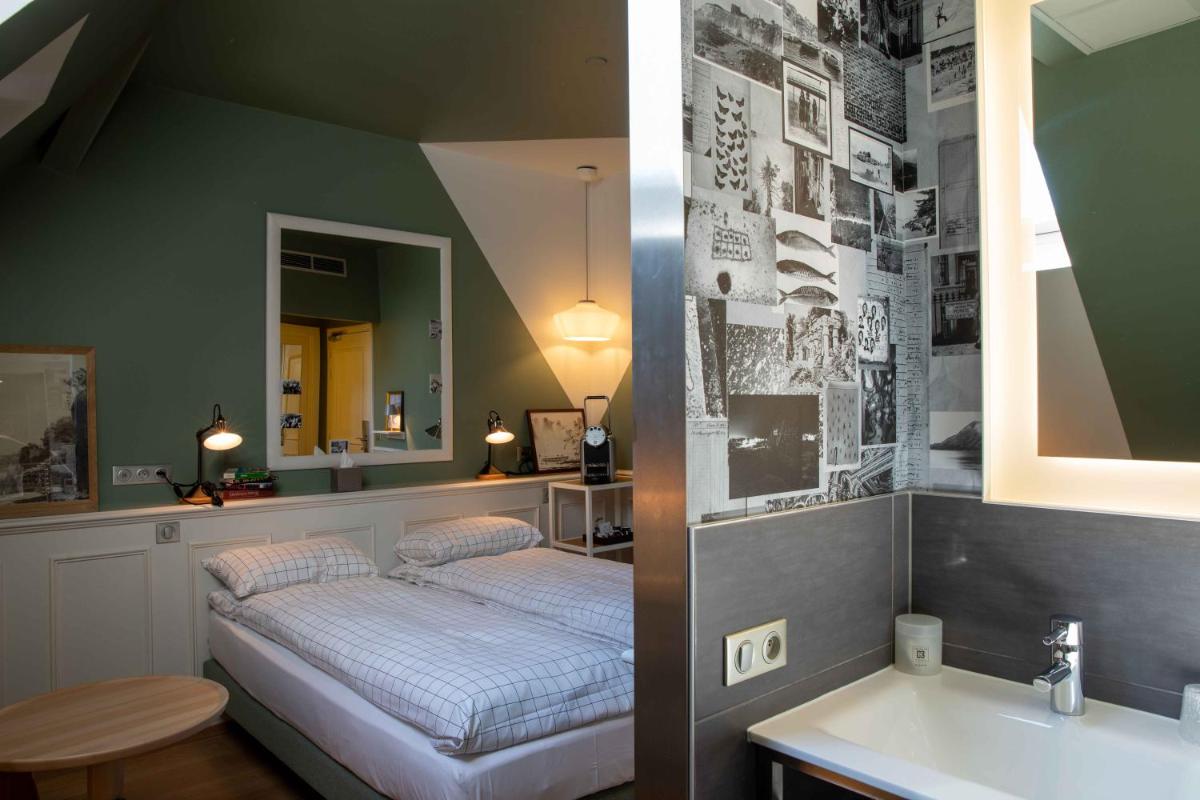 une chambre avec un lit, un lavabo et un miroir dans l'établissement Hôtel et Spa La Villa K - Basel Airport, à Saint-Louis