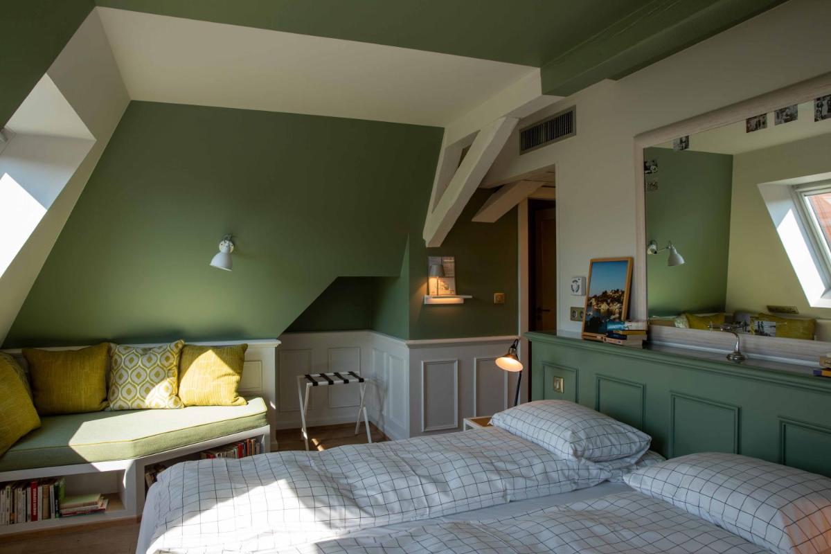 - une chambre avec 2 lits et un mur vert dans l'établissement Hôtel et Spa La Villa K - Basel Airport, à Saint-Louis