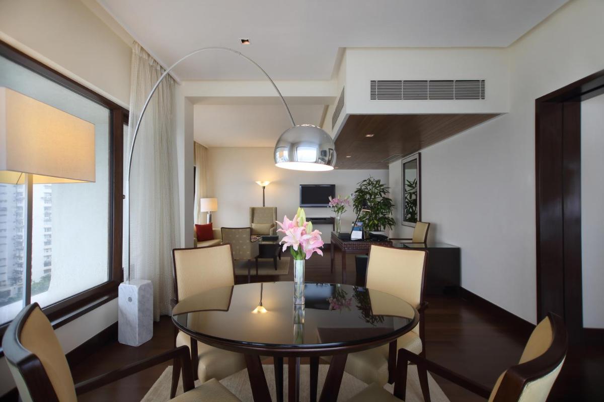 a dining room with a table and chairs at The Oberoi Mumbai in Mumbai