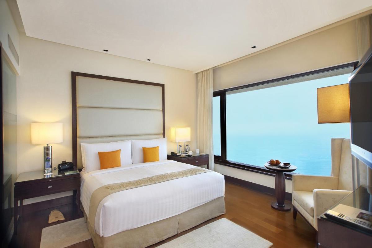 a bedroom with a large bed and a large window at The Oberoi Mumbai in Mumbai