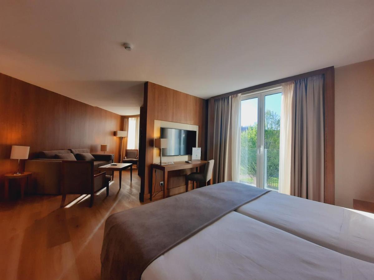 una habitación de hotel con una cama y un televisor en Gran Hotel Balneario De Puente Viesgo, en Puente Viesgo