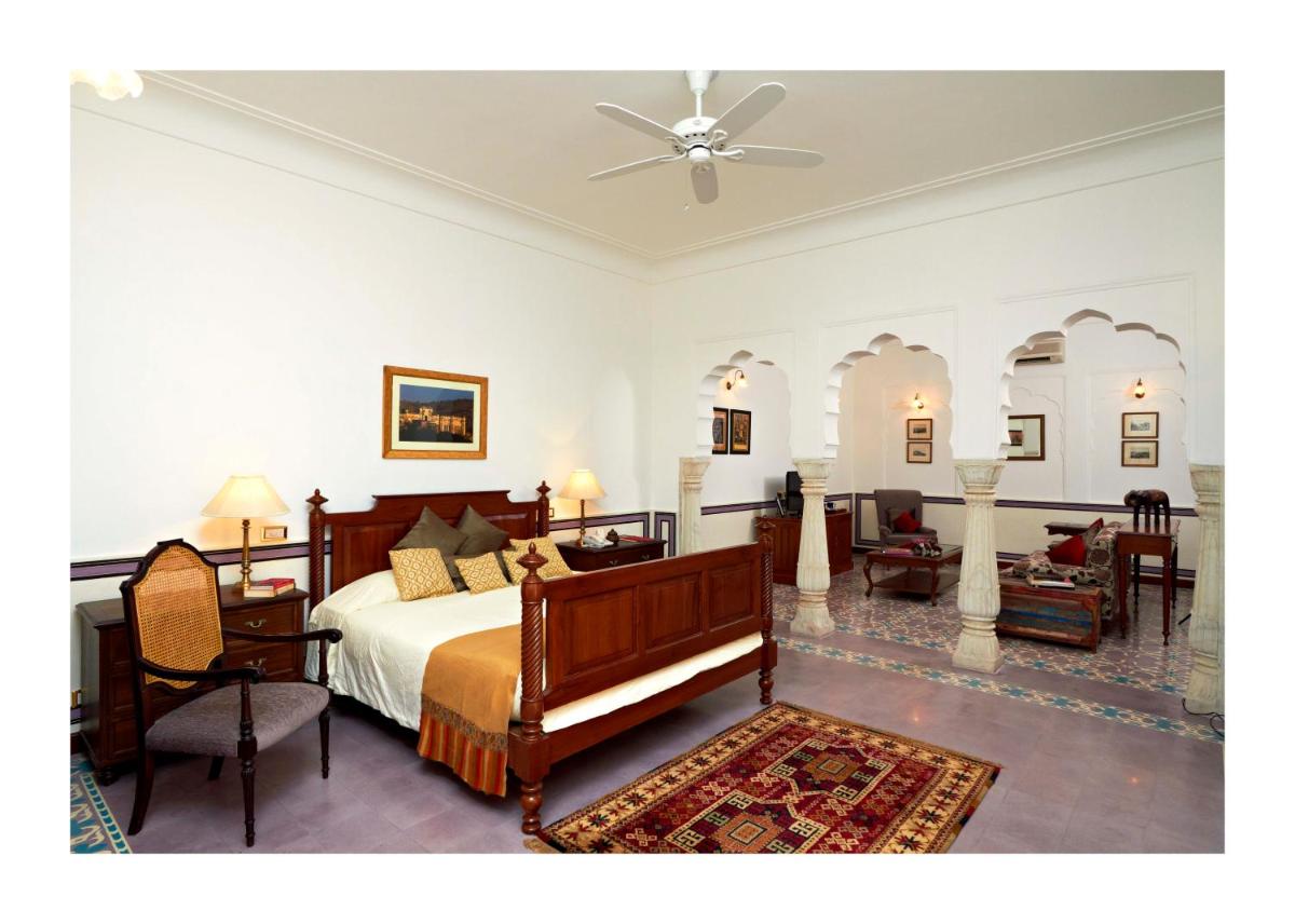 a bedroom with a bed and a living room at Samode Haveli in Jaipur