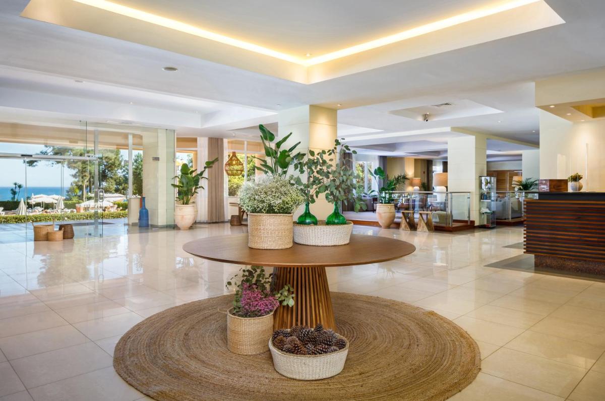 um lobby com uma mesa com vasos de plantas sobre ele em PortoBay Falesia em Albufeira