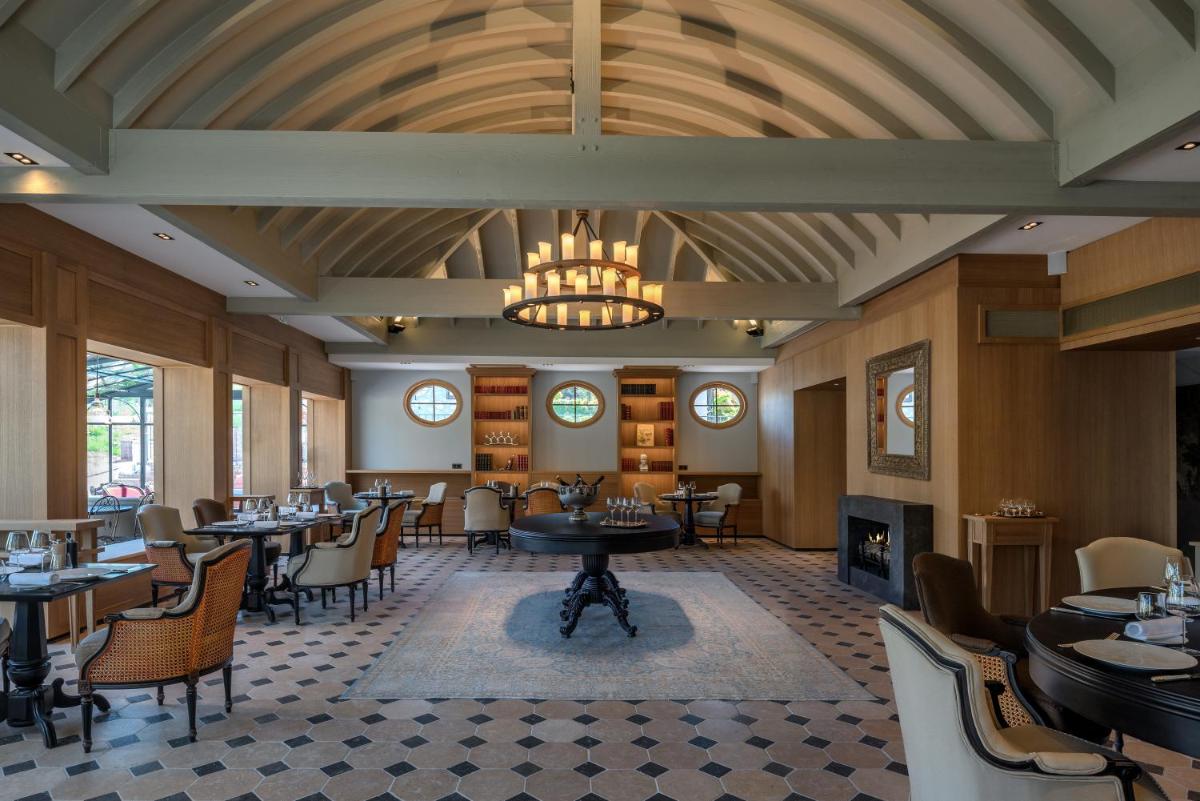 un restaurant avec des tables, des chaises et un lustre dans l'établissement Château Brachet, à Grésy-sur-Aix