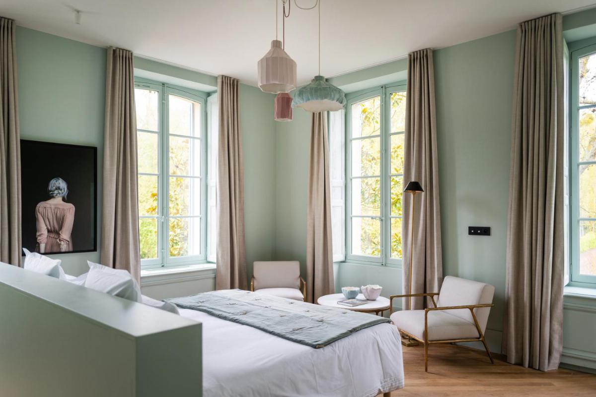 - une chambre avec un lit, 2 chaises et des fenêtres dans l'établissement Le Domaine de Primard, à Guainville