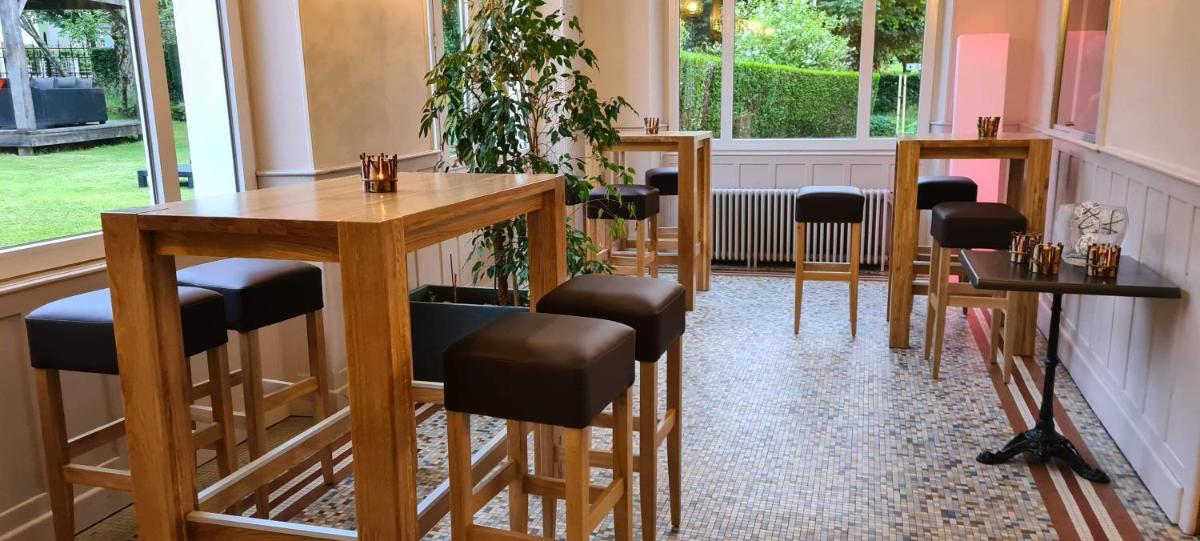 - un bar avec tabourets et une table dans une pièce dans l'établissement Le Castelet, à Le Mont-Dore