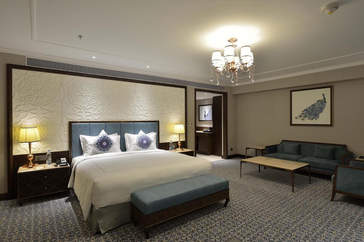 a large hotel room with a bed and a couch at Taj Skyline Ahmedabad in Ahmedabad