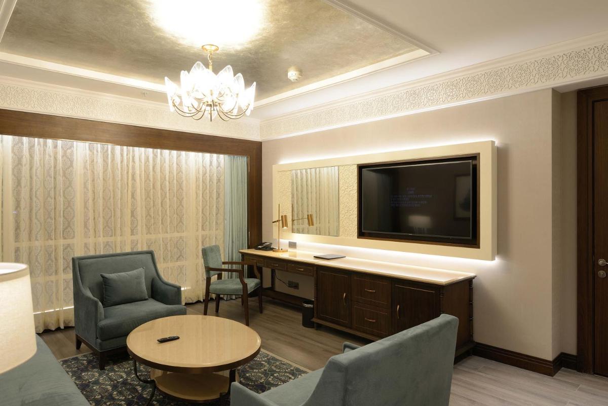 a hotel room with a tv and a table and chairs at Taj Skyline Ahmedabad in Ahmedabad