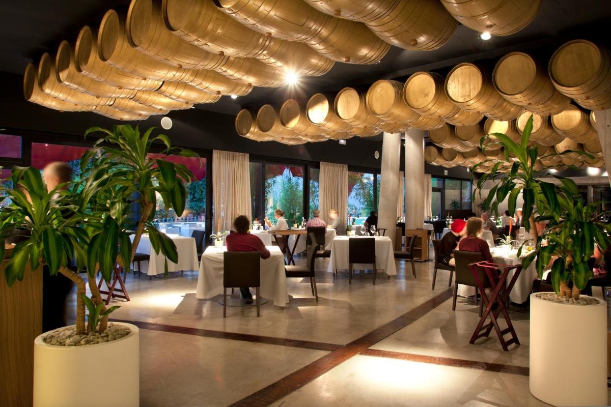 un restaurante con gente sentada en mesas y platos en Hotel Viura, en Villabuena de Álava