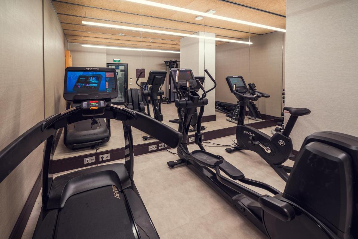 un gimnasio con varias máquinas de correr y TV en Catalonia Gran Vía Bilbao, en Bilbao