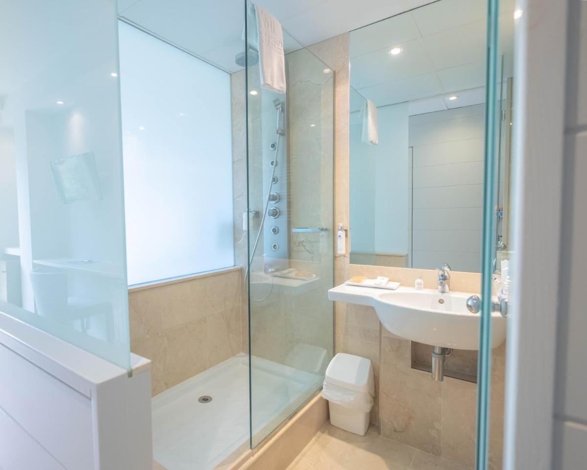 Un baño con ducha, lavabo e inodoro. en S'Agaró Hotel Spa & Wellness, en S'Agaró