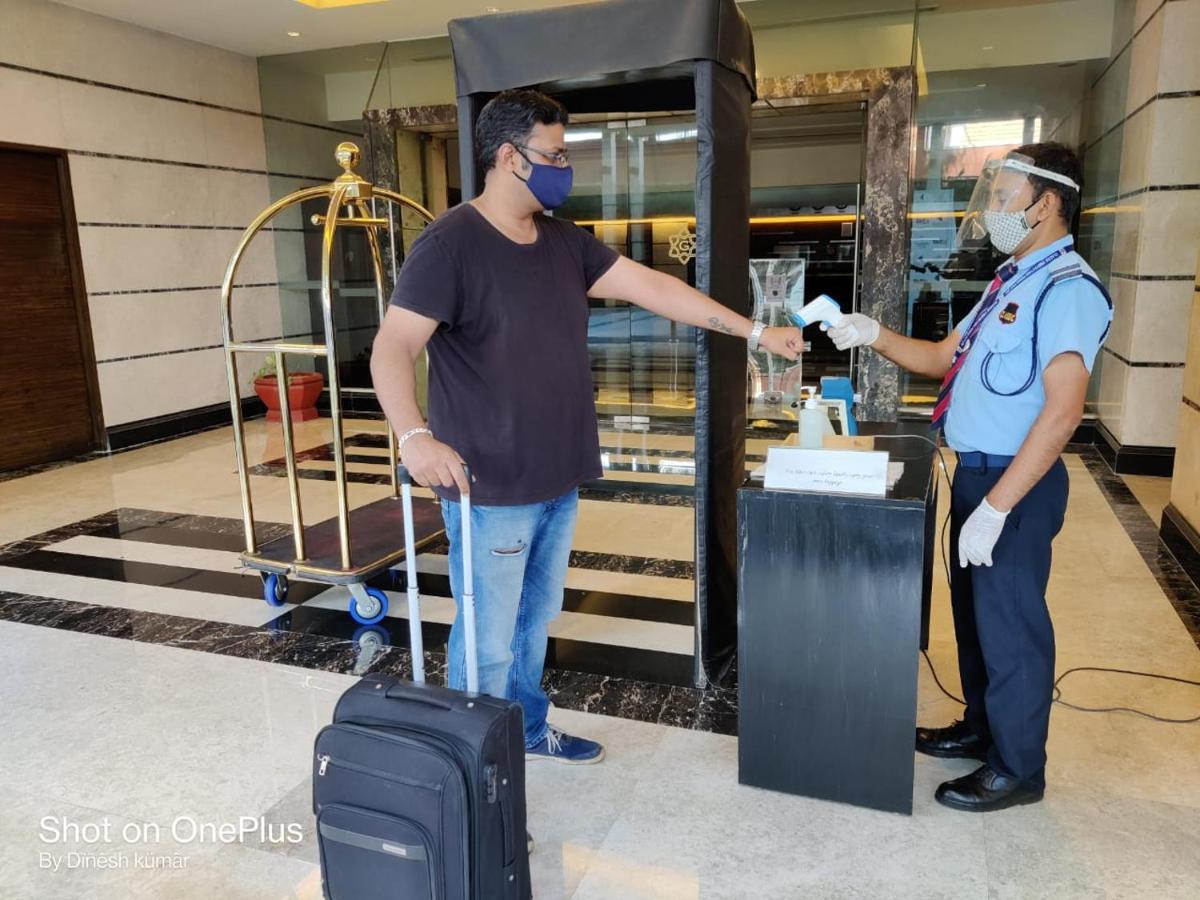 a man with a mask and a police officer with a suitcase at Gokulam Grand Hotel & Spa Bangalore in Bengaluru a man with a mask and a police officer with a suitcase at Gokulam Grand Hotel & Spa Bangalore in Bengaluru