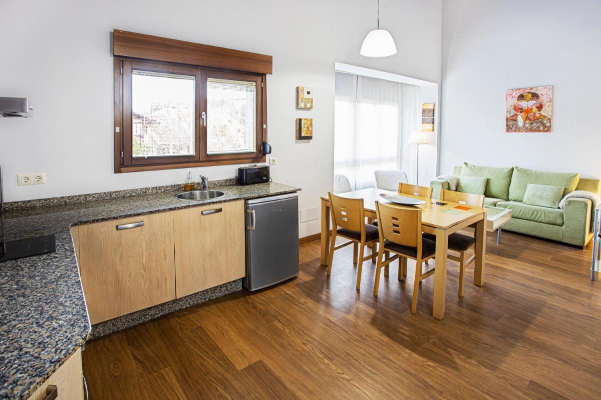 cocina y sala de estar con mesa, cocina y comedor en LA CASONA Encanto Rural - ApartaHotel SPA Llanes, en Llanes