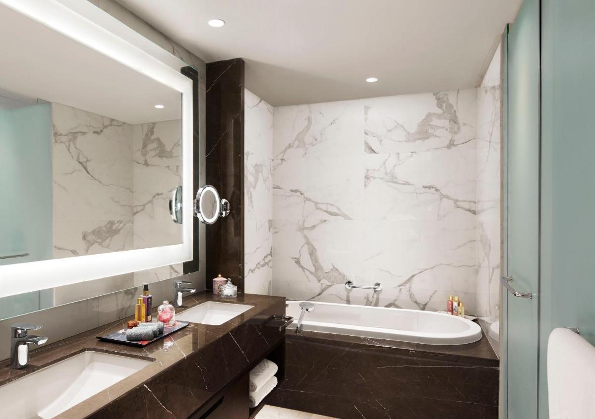 a bathroom with two sinks and a bath tub at Taj Wellington Mews Chennai in Chennai