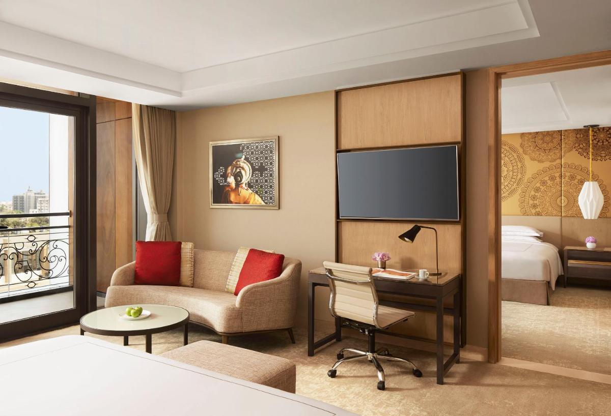 a hotel room with a bed and a living room at Taj Wellington Mews Chennai in Chennai