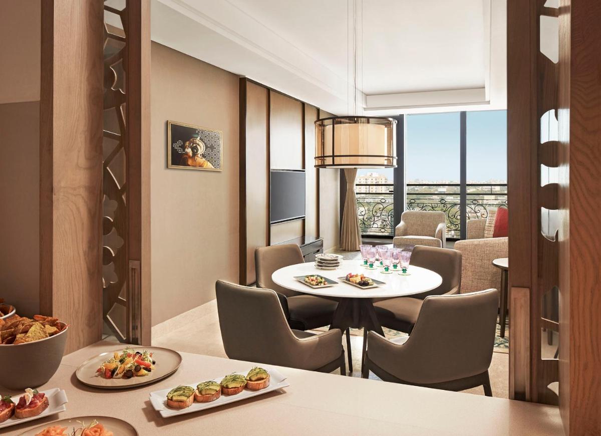 a dining room with a table and chairs with food at Taj Wellington Mews Chennai in Chennai