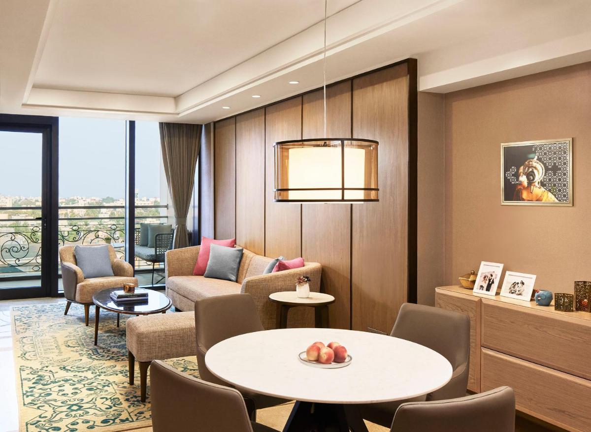 a living room with a table and chairs at Taj Wellington Mews Chennai in Chennai