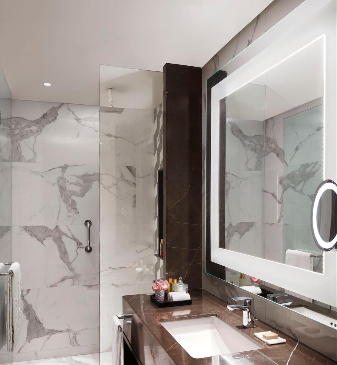 a bathroom with a sink and a mirror at Taj Wellington Mews Chennai in Chennai