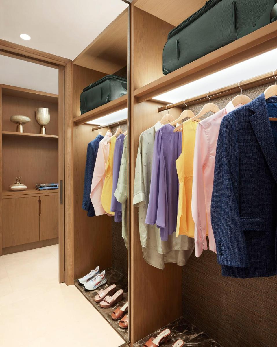 a walk in closet with colorful clothes and shoes at Taj Wellington Mews Chennai in Chennai
