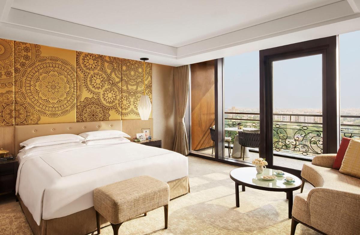 a bedroom with a bed and a large window at Taj Wellington Mews Chennai in Chennai