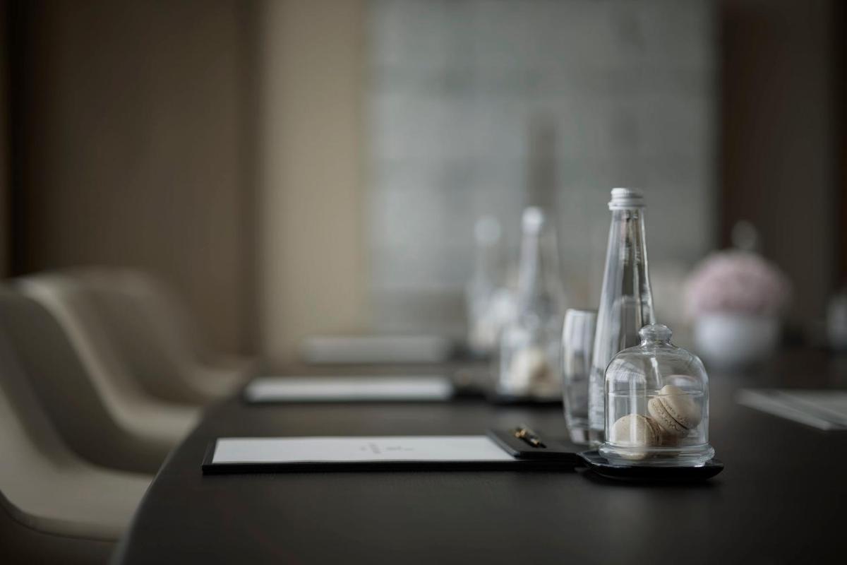 a table with a bottle with shells in it at Taj Wellington Mews Chennai in Chennai