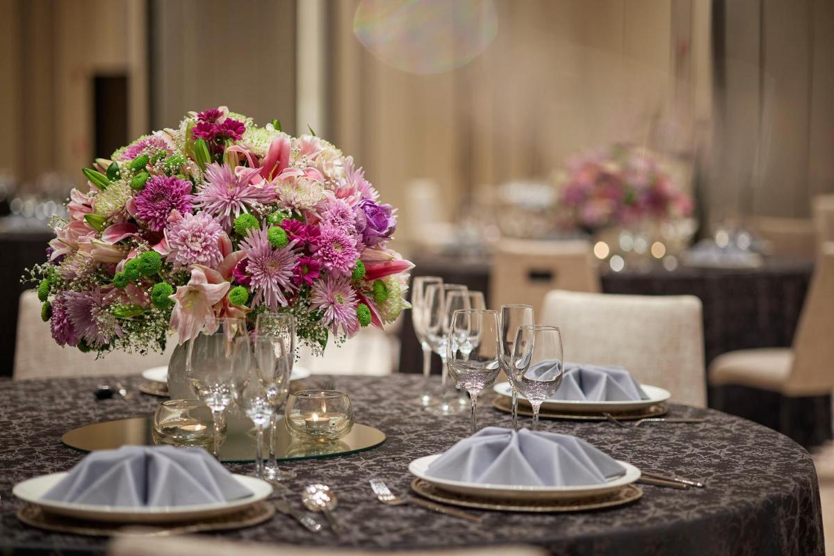 a table with a vase of flowers on top at Taj Wellington Mews Chennai in Chennai