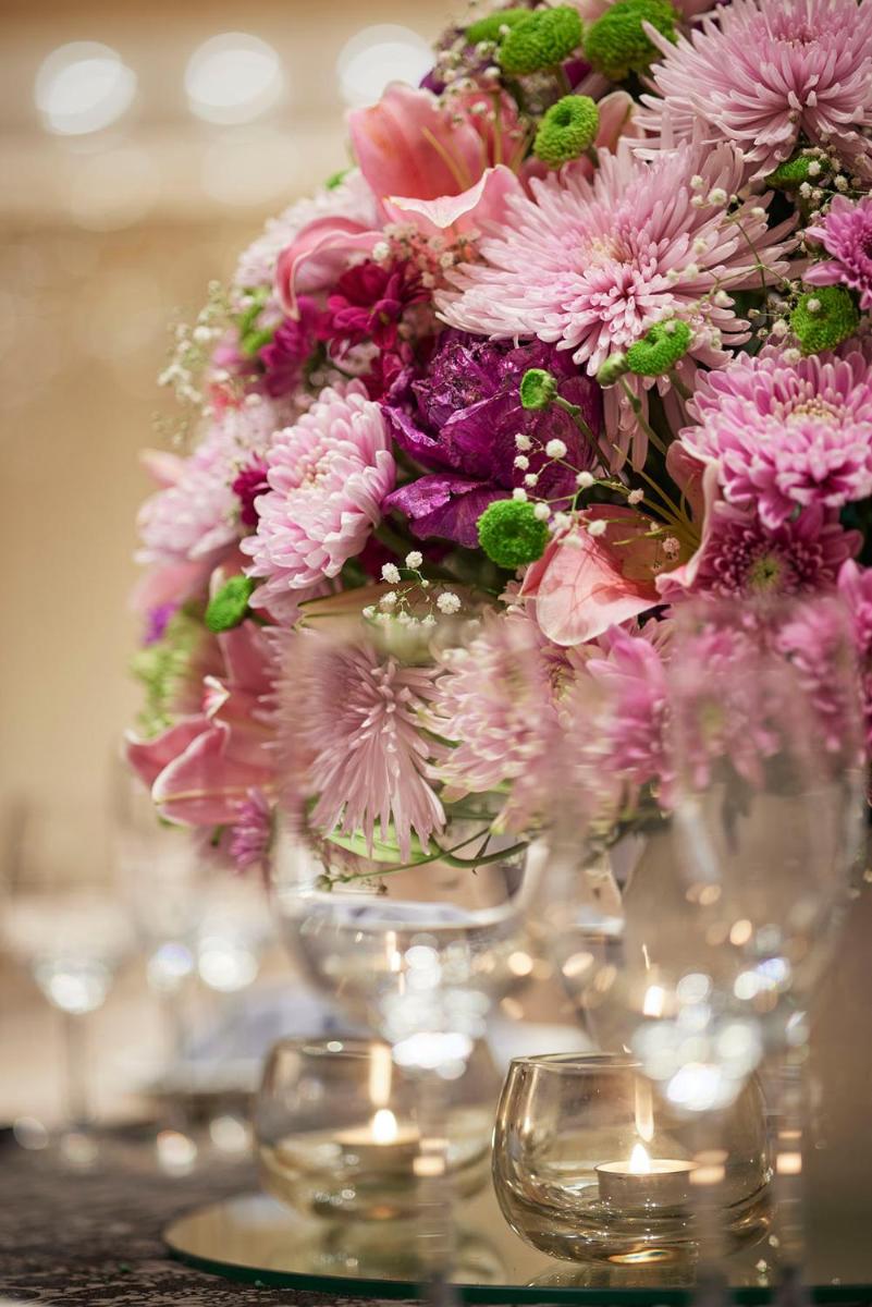 a vase filled with pink flowers on a table at Taj Wellington Mews Chennai in Chennai