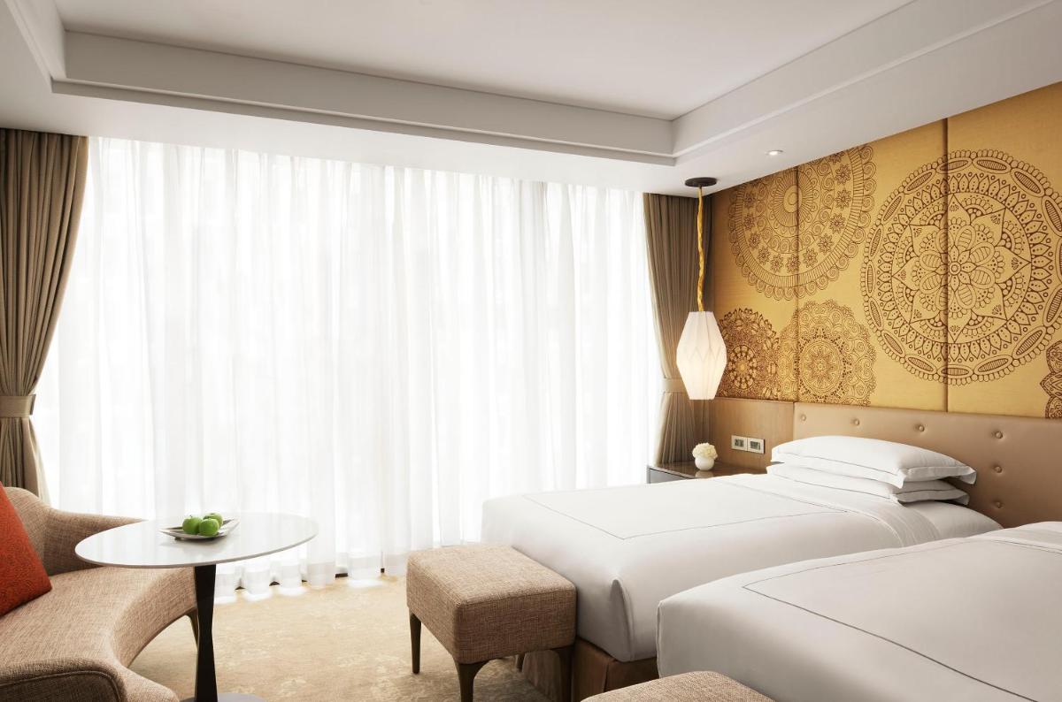 a hotel room with two beds and a table at Taj Wellington Mews Chennai in Chennai