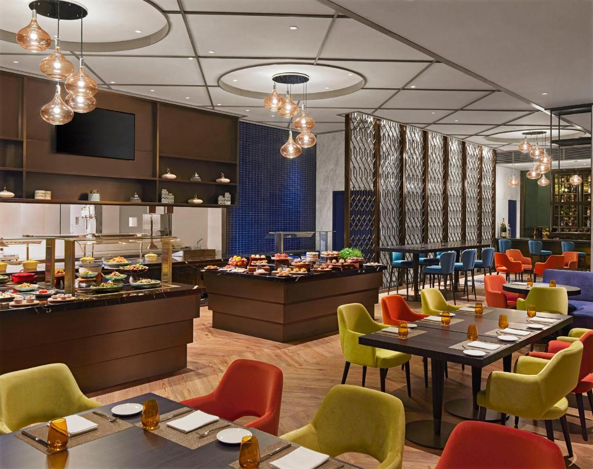 a restaurant with tables and chairs and a buffet at Taj Wellington Mews Chennai in Chennai