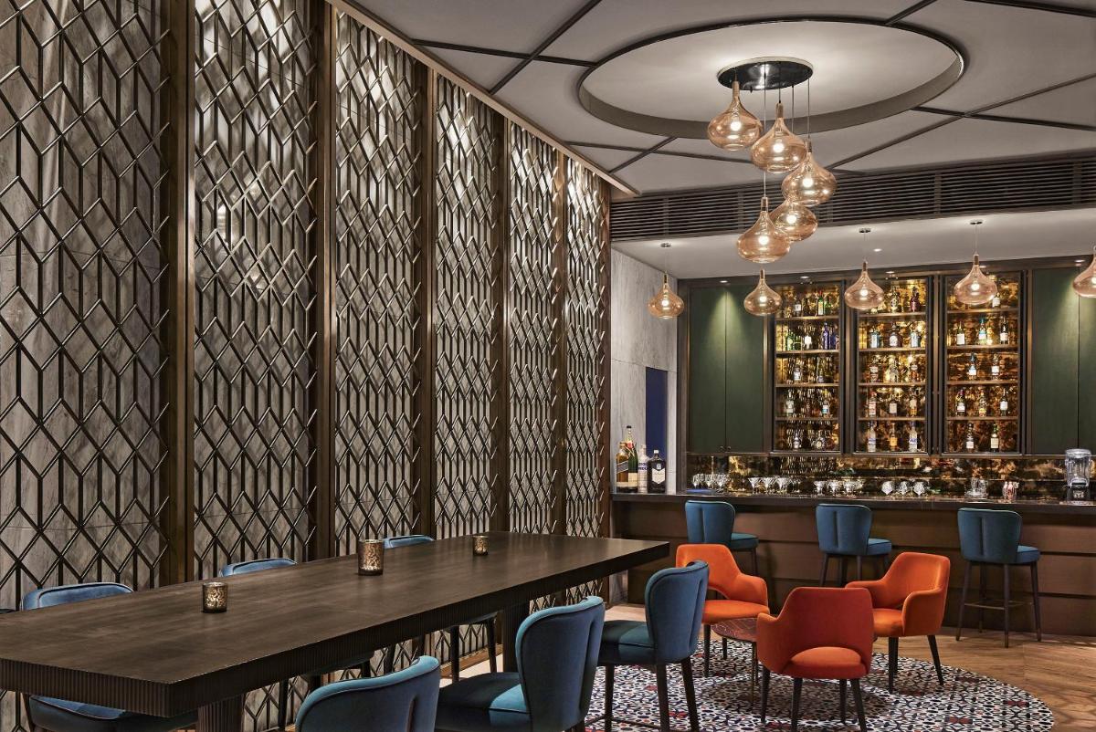 a restaurant with a table and chairs and a bar at Taj Wellington Mews Chennai in Chennai