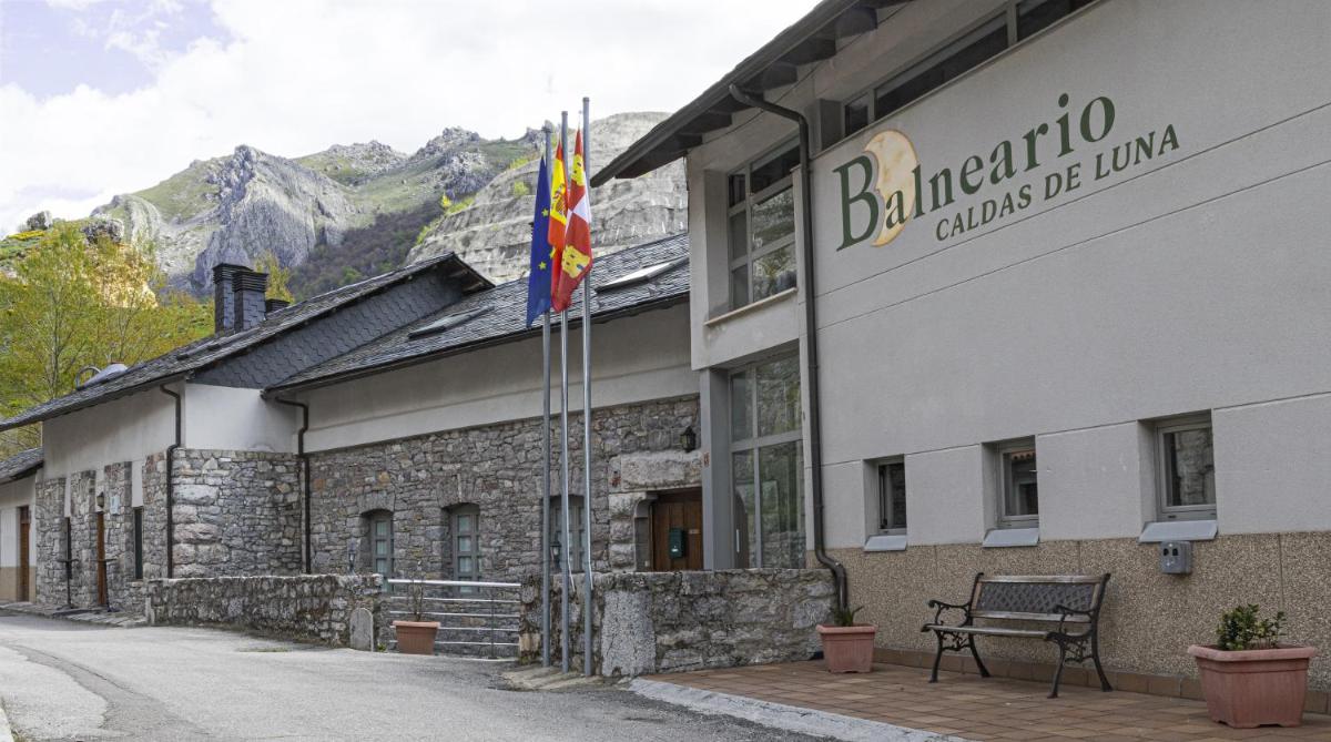 un edificio con dos banderas a un lado en Balneario Caldas de Luna, en Caldas de Luna