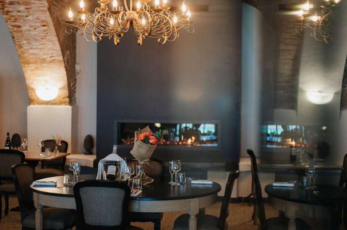 une salle à manger avec tables, chaises et un lustre dans l'établissement Hôtel La Robéyère - BW Signature Collection, à Embrun