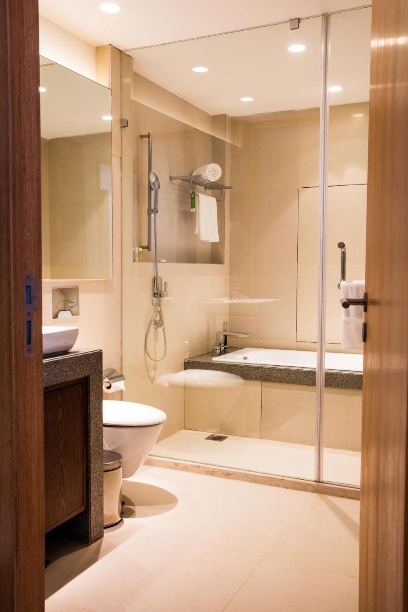 a bathroom with a shower and a toilet and a sink at Oakwood Residence Kapil Hyderabad in Hyderabad