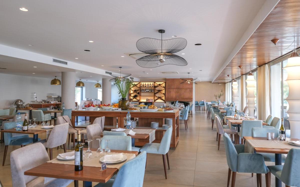 um restaurante com mesas de madeira e cadeiras azuis em Hotel Vouga nas Termas de São Pedro do Sul