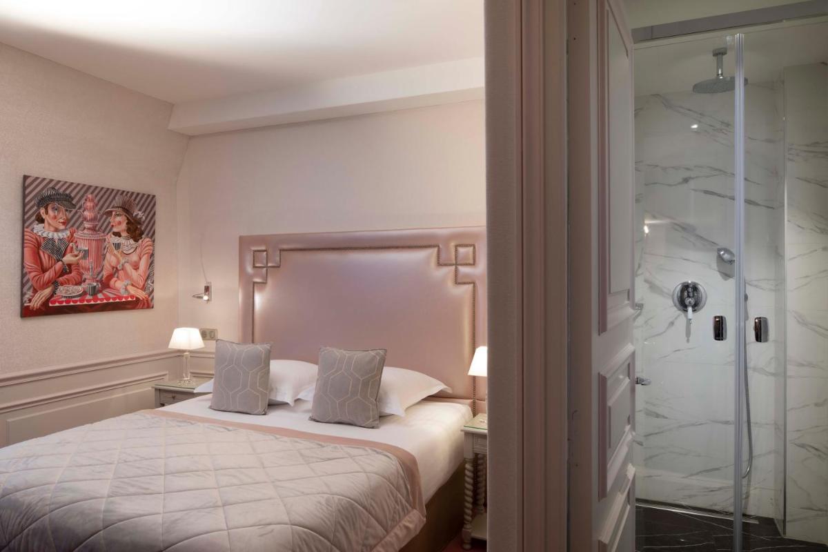 une chambre avec un lit et une douche en verre dans l'établissement Hotel & Spa Saint-Jacques, à Paris