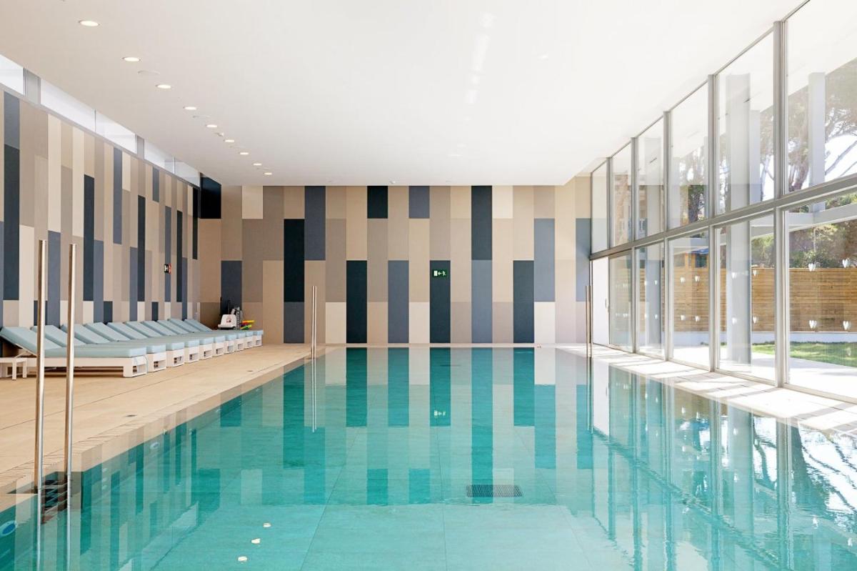 una piscina en un edificio con una ventana grande en Diamant Hotel & Aparthotel, en Cala Ratjada 49 fotos más